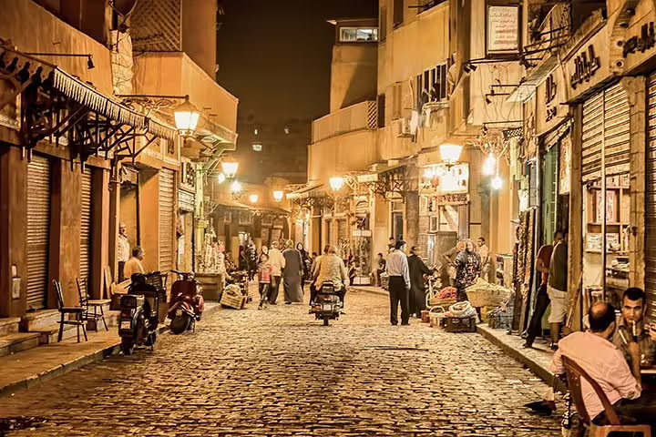 Nighttime walk on Al Moez Street, Islamic Cairo bazaar lights and local vendors on Cairo by Night tour