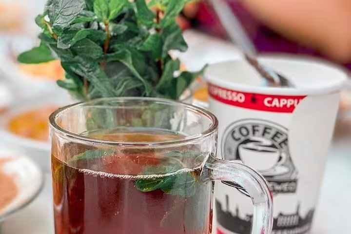 Mint tea and cappuccino on a café table, a classic stop on Cairo by Night tour near Al Fishawi café