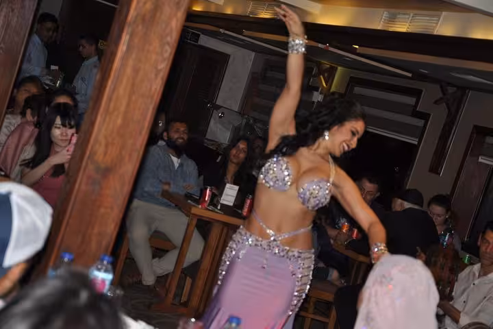 Belly dance performance during deluxe Cairo Nile dinner cruise with live entertainment and seated guests