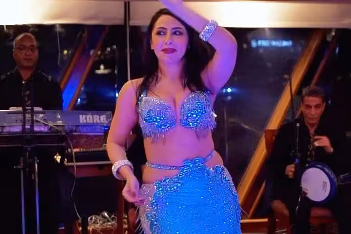 Belly dancer performing with live band on a Cairo Nile dinner cruise, evening entertainment on a luxury boat