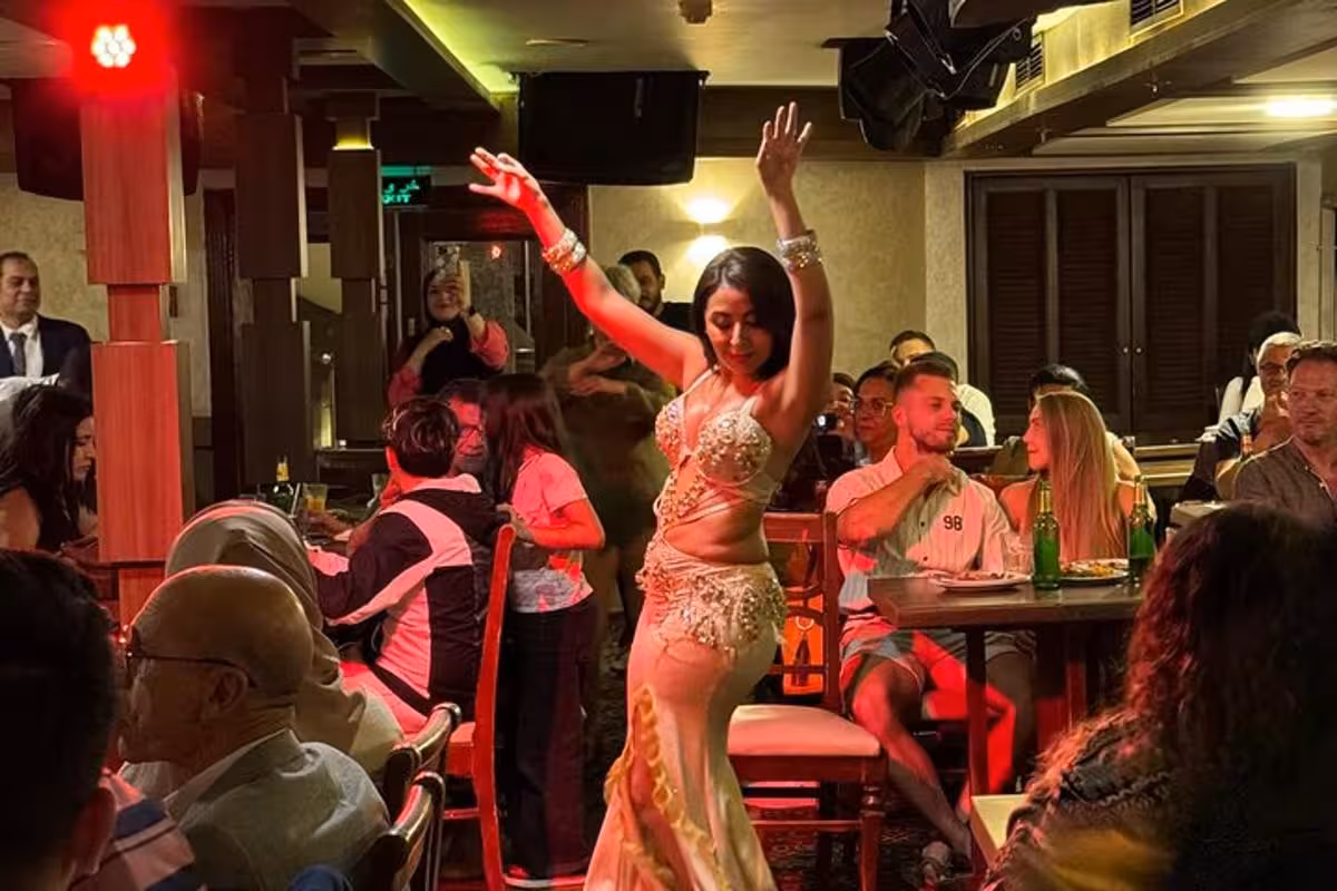 Belly dancer performs on a Cairo Nile dinner cruise with transfer, entertaining guests under warm lights