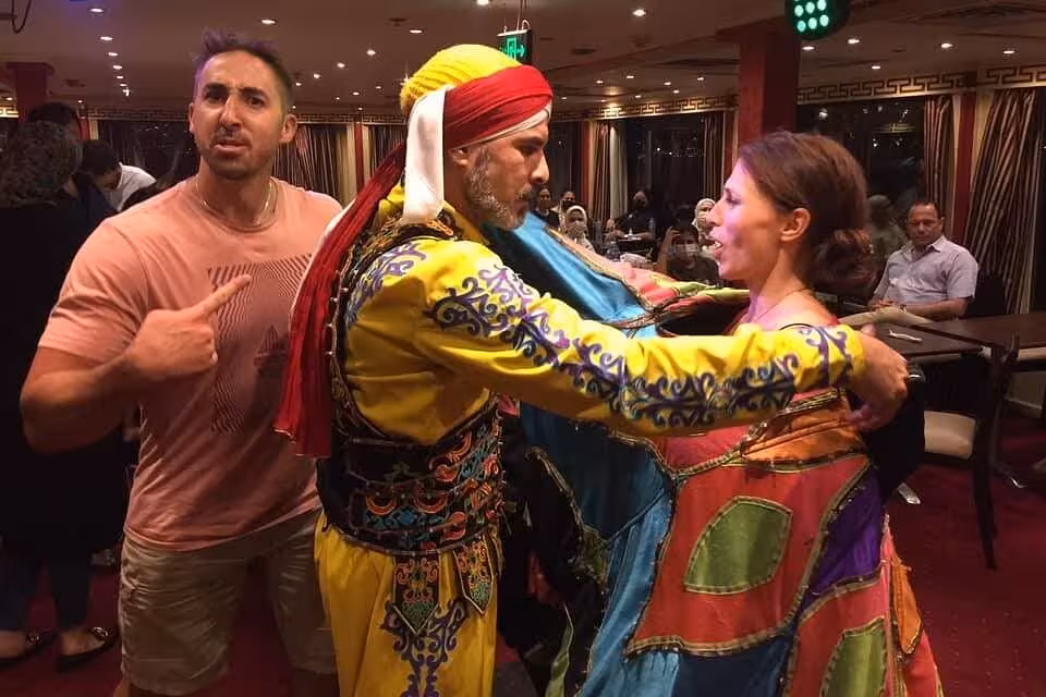 Guests join Egyptian folklore dance on a Cairo Nile dinner cruise with live music and onboard show