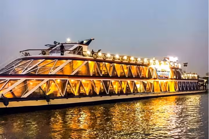 Illuminated Nile dinner cruise ship glowing with golden lights reflected on the river at night in Cairo