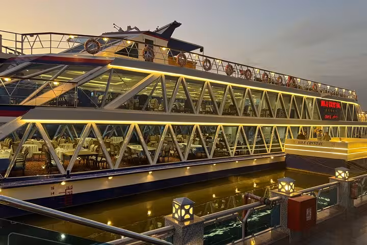 Illuminated Nile Crystal dinner cruise boat in Cairo at sunset, glass-deck dining and evening Nile sailing