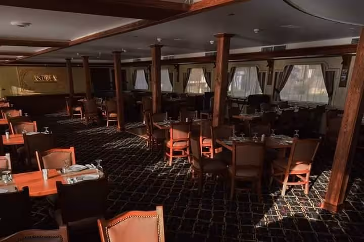 Indoor dining hall on Cairo Nile River dinner cruise boat, set tables for evening meal and show
