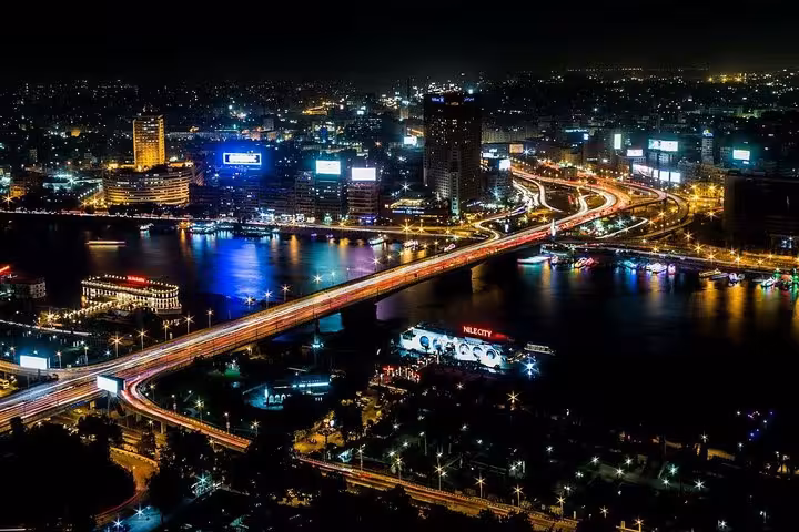 Cairo skyline at night over the Nile River, city lights and bridges seen during an evening dinner cruise