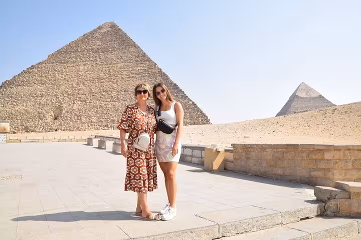 Two women posing at Giza Pyramids viewpoint on a Cairo private tour, ideal for Egyptian Museum and bazaar