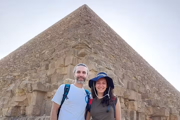 Travelers posing by the Great Pyramid of Giza on a Cairo private tour to Giza Pyramids and Grand Egyptian Museum