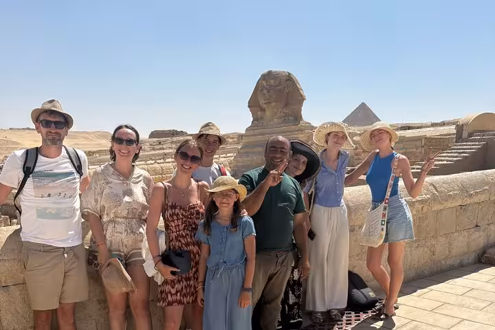 Tour group at Great Sphinx and Giza Pyramids on exclusive Cairo day tour with camel ride and desert bikes