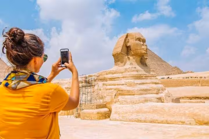 Traveler photographing the Great Sphinx and Giza Pyramid on a Cairo pyramids day tour with Sakkara and lunch