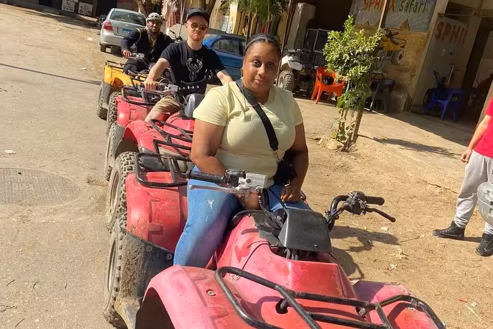Travelers lined up on quad bikes for Cairo desert adventure tour with camel ride, lunch and local shopping stop