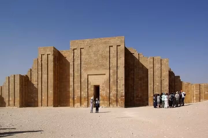 Tour group visiting the Saqqara complex near Cairo, exploring ancient stone temple ruins on a private tour