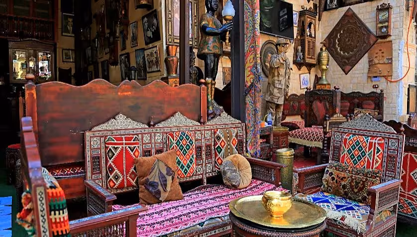 Traditional Egyptian wooden furniture with colorful geometric patterns in a Cairo souq antique shop