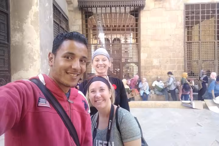 Tour guide and guests selfie in Old Cairo courtyard during private 3-day Cairo Giza Alexandria tour