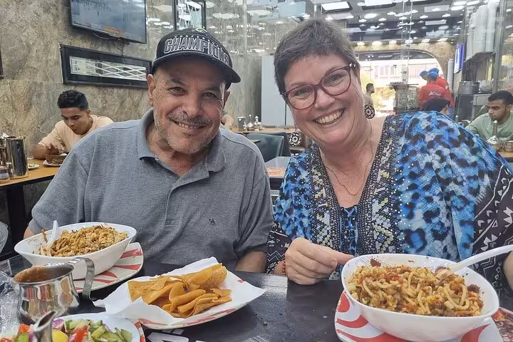 Tourists enjoying Egyptian koshari in downtown Cairo restaurant, a tasty stop on 4-day Cairo tour with hotel