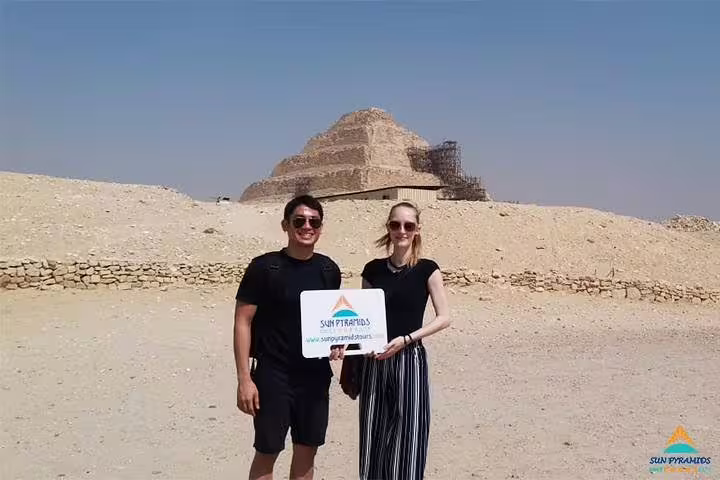 Travelers at the Pyramid of Djoser in Saqqara on a 5 day Cairo vacation package, desert backdrop