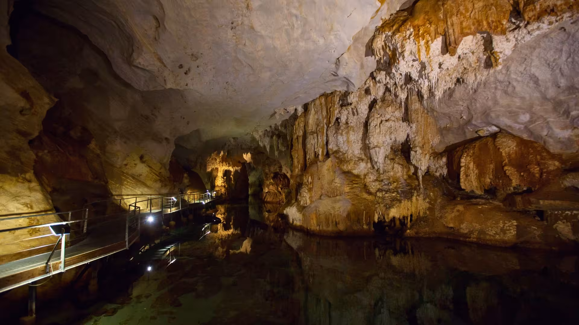 Explore stunning rock formations inside Bue Marino Caves on a motorboat tour from Cala Gonone, showcasing illuminated paths.