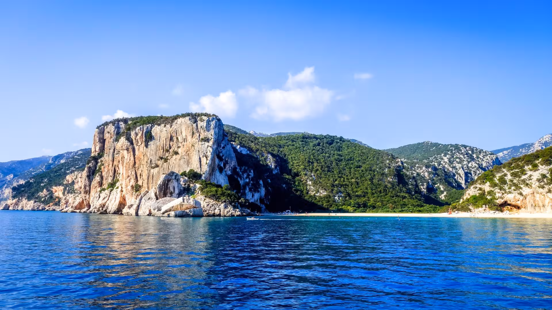 Stunning cliffside landscape of Cala Gonone with vibrant greenery and deep blue sea, perfect for exploring by boat.