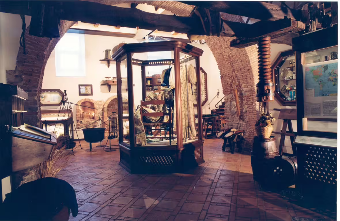 Charming museum room inside a Calabrian castle with rustic brick arches, vintage tools and curated historical displays