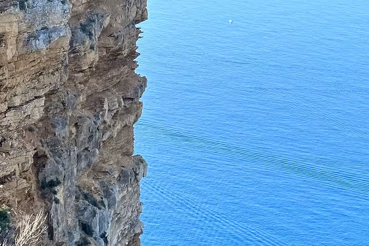 Limestone cliff above turquoise Calanques waters near Cassis on fullday Aix-en-Provence and Marseille tour