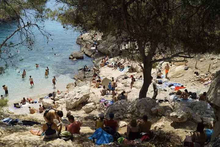 Swimmers relax on a rocky cove in Calanques National Park near Marseille on a guided coastal hike