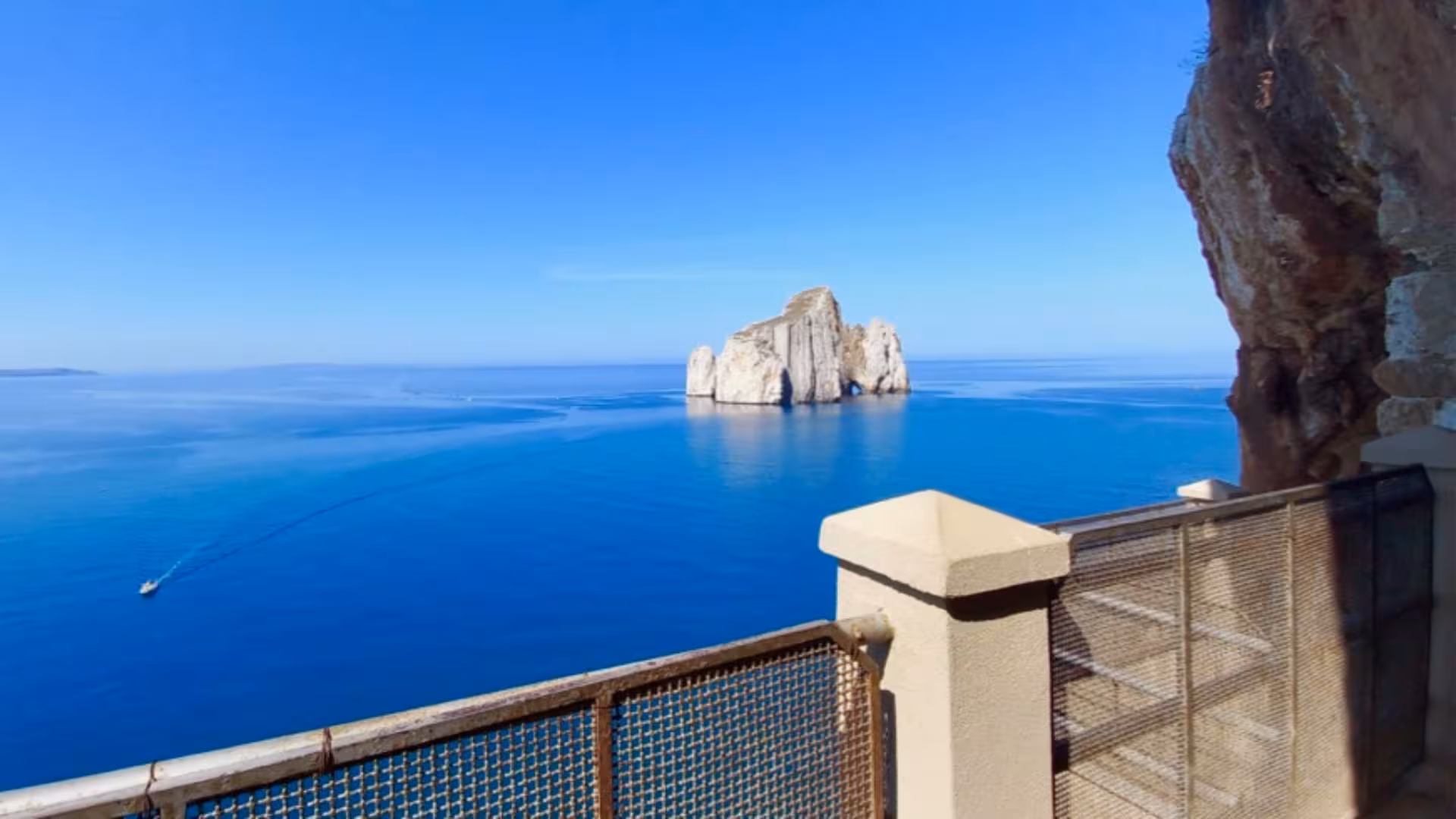 Dramatic seascape from a viewpoint in Calasetta, showcasing pristine waters and majestic rock formations.