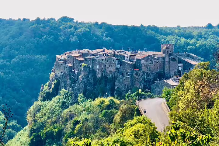 Scenic road leading to Calcata Vecchia perched on a dramatic cliff above woodland on a Rome VIP private tour