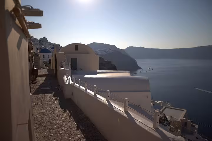 Caldera walkway in Oia with whitewashed cave houses and sea views, Santorini Iconic Highlights Tour