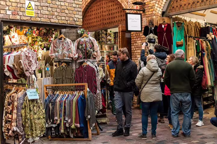 Visitors explore vibrant vintage clothing stalls at Camden Market, a highlight of the London Unexpected Private Tour.