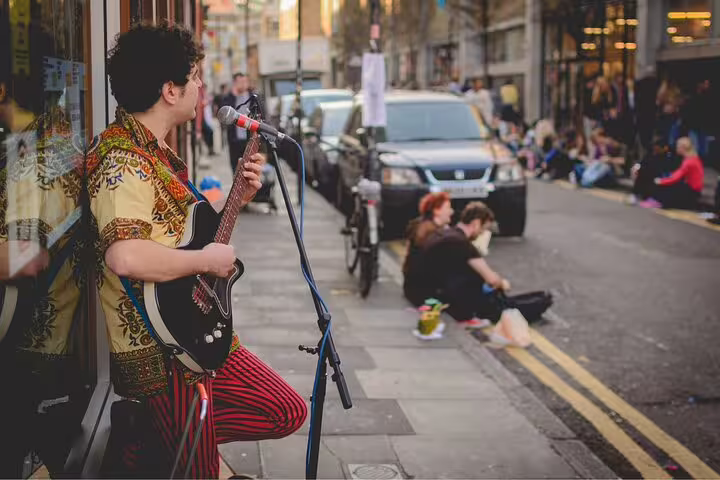 Street musician performing in vibrant Camden Town, capturing the essence of London's markets and street art culture.