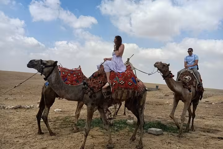 Camel caravan in the Giza desert with travelers on a private Giza Pyramids and Sphinx camel ride adventure