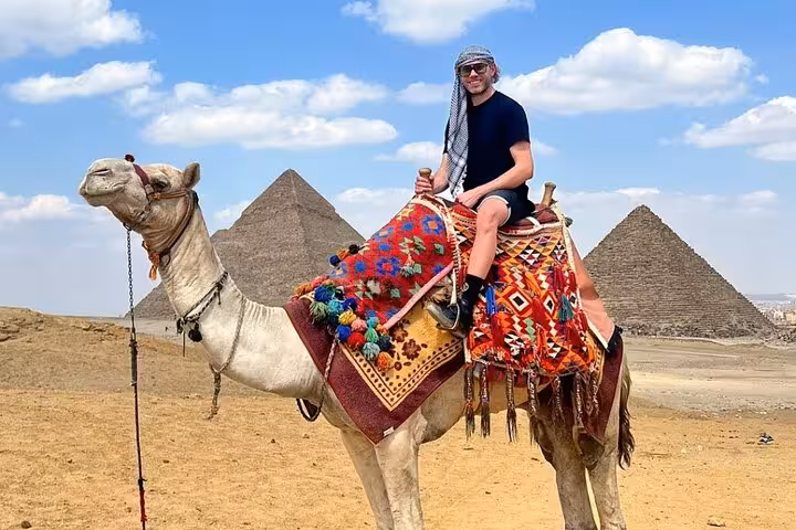 Camel ride at the Giza Pyramids with colorful saddle on all-inclusive Cairo tour with bazaar visit
