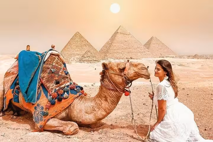 Camel ride photo stop with Giza Pyramids in background on Cairo and Pyramids bus tour from Sharm