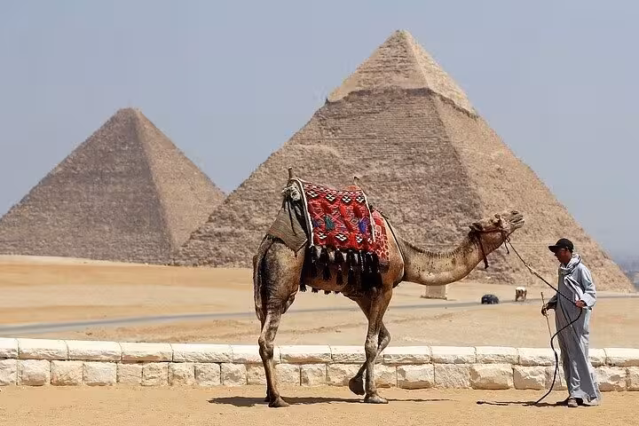 Camel ride at Giza Plateau with pyramids backdrop on Cairo and Pyramids day tour by bus from Sharm El Sheikh