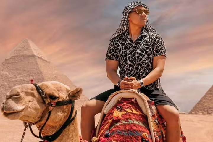 Tourist riding a camel at Giza Pyramids at sunset on a private 2-day Cairo tour with guide