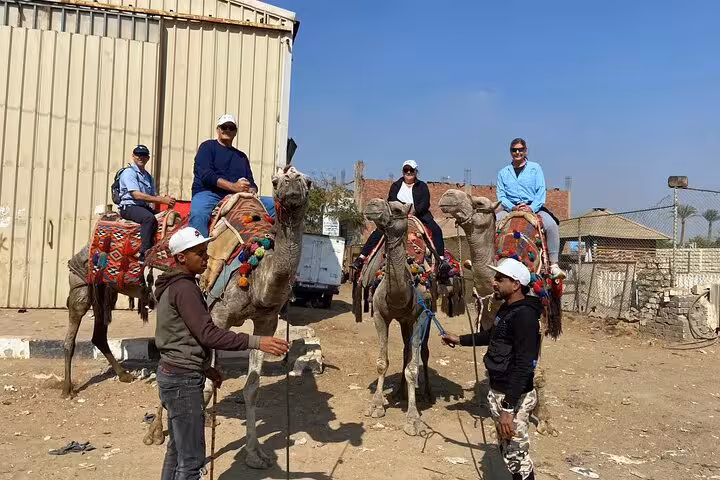 Travelers riding decorated camels near Cairo on a desert tour with lunch, local shopping and photo stops