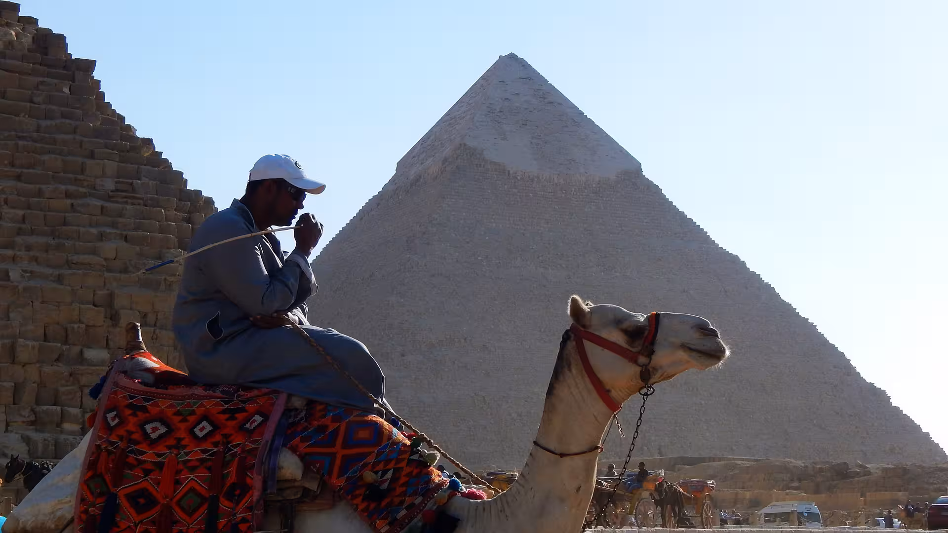 Man riding a camel in front of the Pyramid of Khafre at Giza Pyramids complex, Egypt