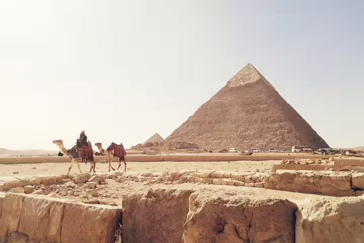 Camel riders near the Great Pyramid of Giza on Cairo tour from Alexandria with return transfer to Port Said