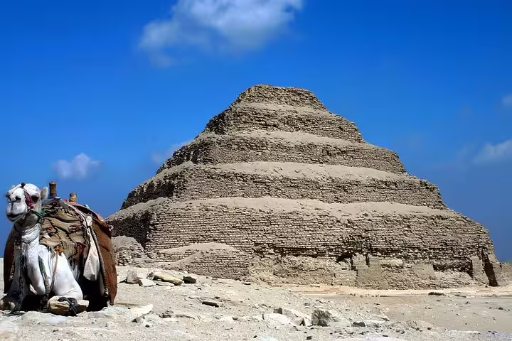 Camel resting beside the Step Pyramid of Djoser at Saqqara necropolis, a highlight of Memphis and Sakkara tours
