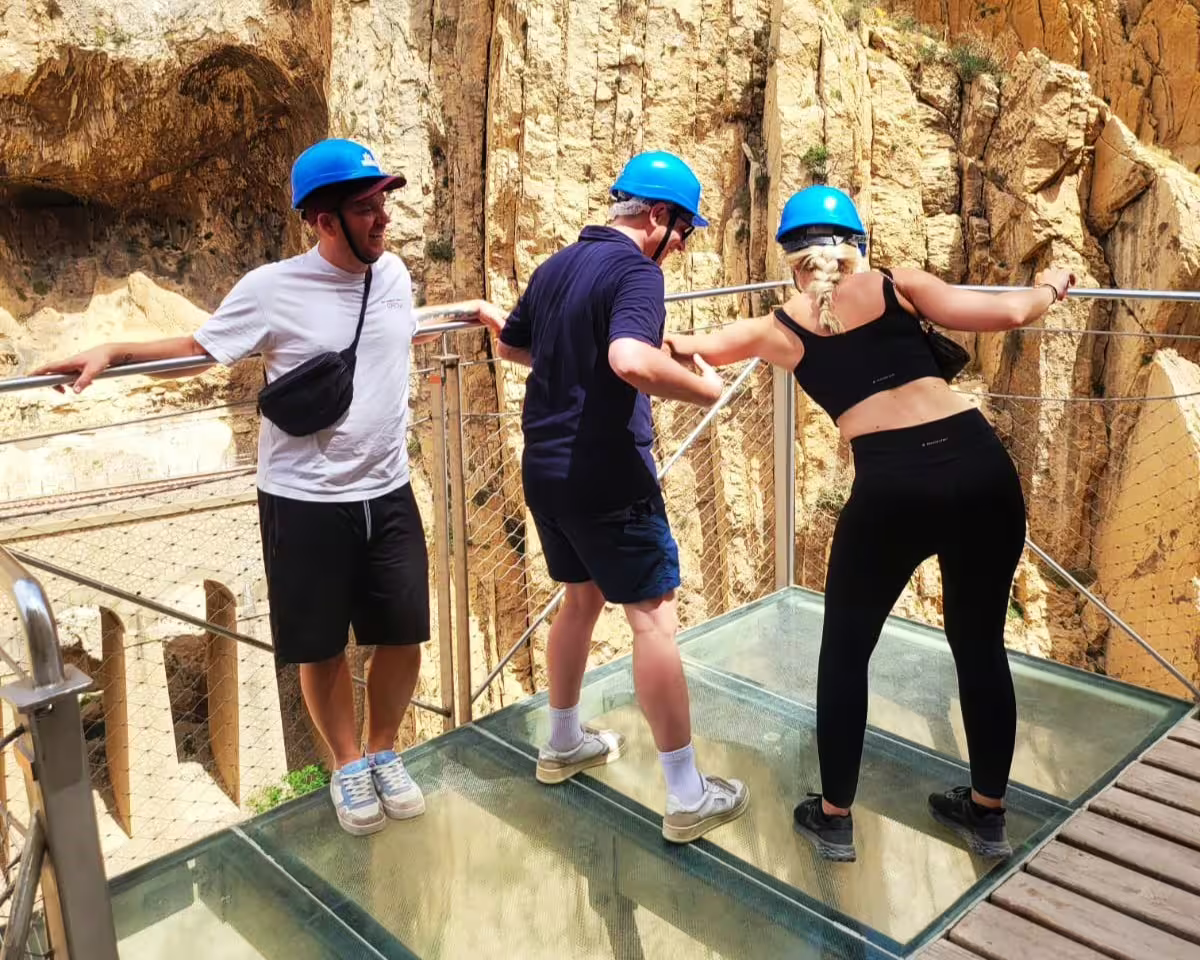 Visitors in helmets on Caminito del Rey glass viewpoint above El Chorro cliffs during private walking tour