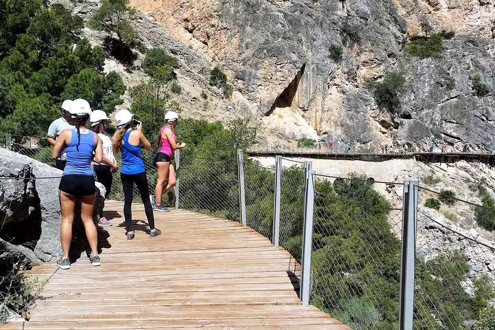 Hikers in helmets on Caminito del Rey boardwalk during private guided tour from Marbella or Malaga