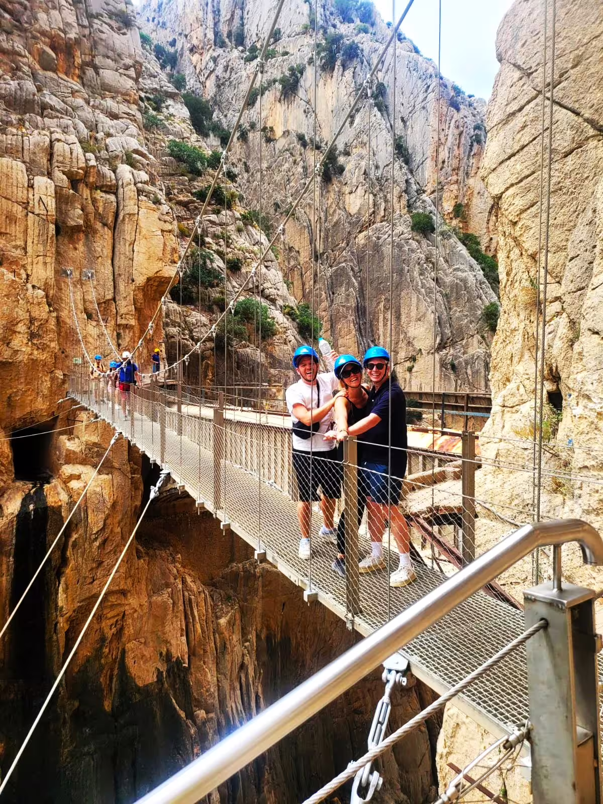 Group wearing helmets on the Caminito del Rey suspension bridge during a private guided day trip from Malaga
