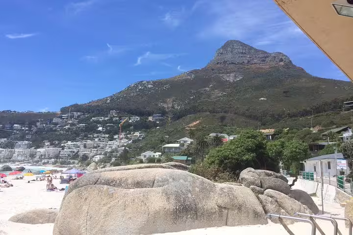 Sunny day at Camps Bay beach with stunning views of Lion's Head and beachfront properties in Cape Town.