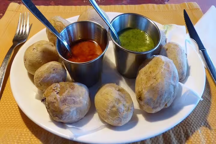 Traditional Canarian wrinkled potatoes with red and green mojo sauces, featured on Tenerife's enogastronomic tour.