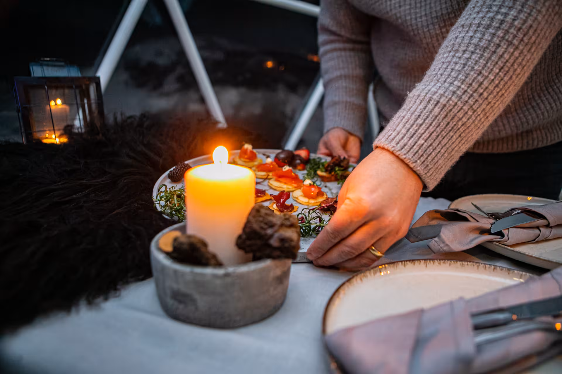 Candlelit lakeside wine tasting setup with gourmet appetizers and cozy ambiance for an evening food pairing experience