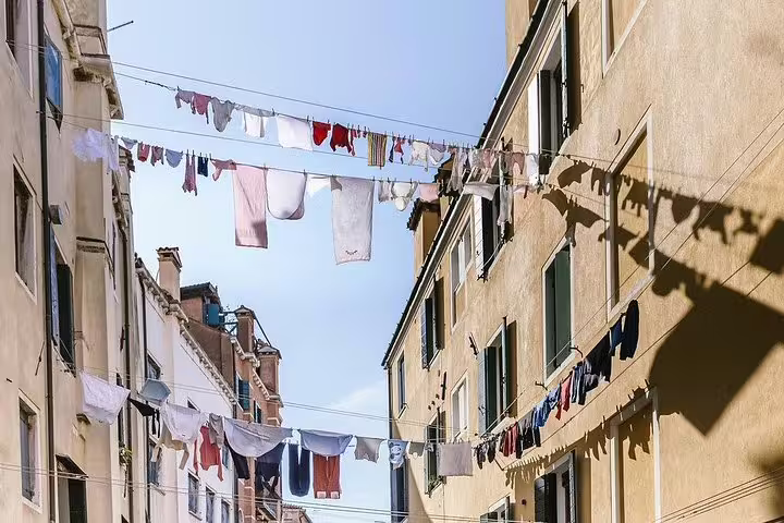 Colorful laundry hanging between historic buildings in the Cannaregio district, showcasing local Venetian life.