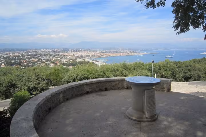 Panoramic viewpoint overlooking Cannes bay and coastline from hilltop terrace with orientation table