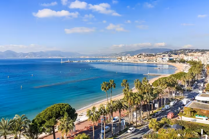 Aerial view of Cannes beach and palm-lined promenade along the French Riviera coastline