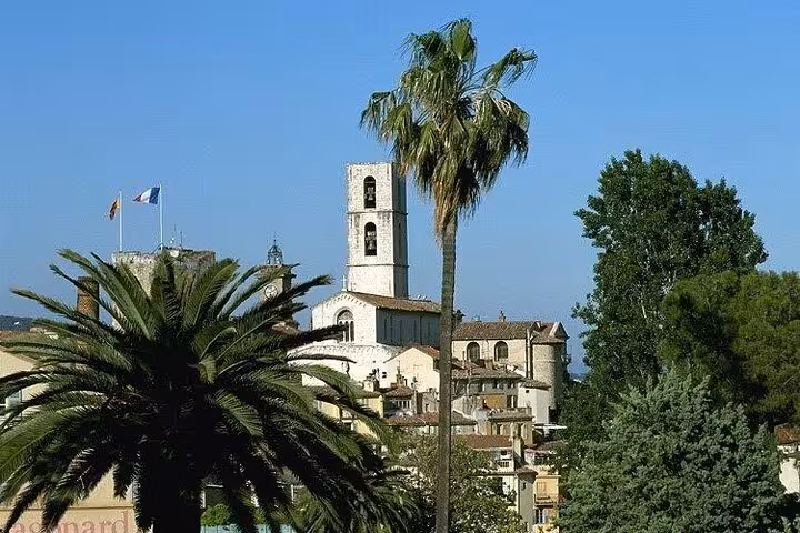Medieval church tower and palm trees in a Provence hilltop village near Cannes, France
