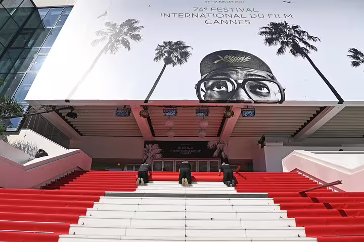 Red carpet stairs at Cannes Film Festival venue with 74th festival poster on building facade